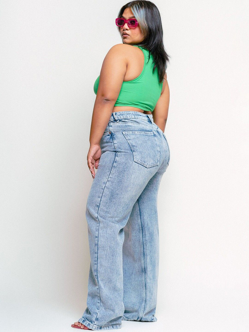 Women's light blue loose wide leg high-rise jeans with highly distressed detailing and heavy fade.