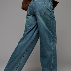 Women's green flared high-rise stretchable jeans with low distress and heavy fade detailing.
