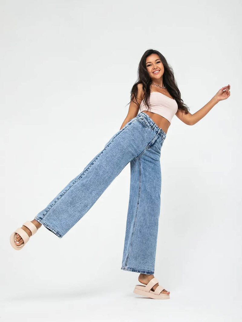 Women’s light blue wide leg high-rise stretchable jeans with low distress and heavy fade detailing.