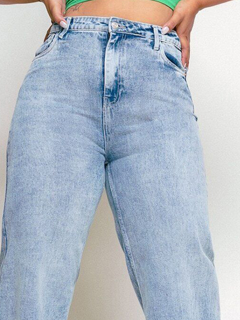 Women's light blue loose wide leg high-rise jeans with highly distressed detailing and heavy fade.