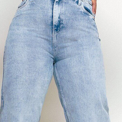 Women's light blue loose wide leg high-rise jeans with highly distressed detailing and heavy fade.